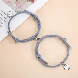 Handmade braided magnetic couple bracelets featuring cute smiley face charms in grey color.