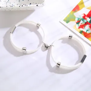 Koppel magnetisch hart witte gevlochten touw armband detail, bijpassende roestvrijstalen bedels.