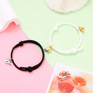 Close-up details of the couple magnetic matching bracelets showing alloy heart locks and rope.