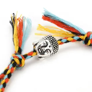 Detailed shot of a handmade braided rope bracelet featuring a vintage alloy Buddha head charm.