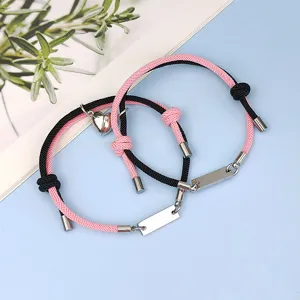 Magnetic couple bracelet set with pink black woven cord and stainless steel heart charms detail