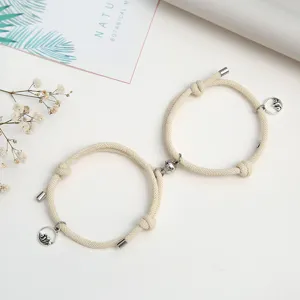 Primo piano di bracciali intrecciati magnetici di coppia con ciondoli in metallo.