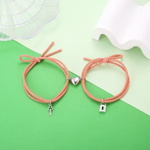 Gedetailleerd overzicht van bijpassende paar armbanden met magnetisch hart, slot en sleutels.