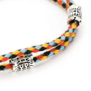 Handmade woven multi-color cotton rope bracelet with vintage alloy metal beads for daily wearing.