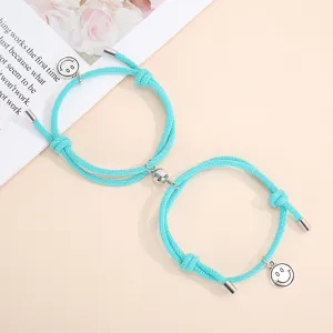 Handmade magnetic couple bracelets with cute smiley charms and woven ropes for lovers.