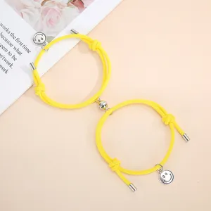 Magnetic couple bracelets with yellow woven rope and cute smiley face pendants for love.