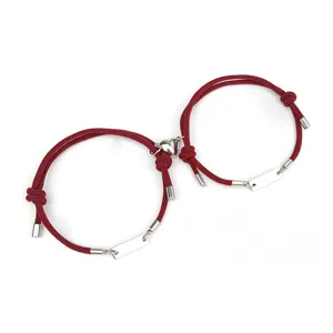 Couple magnetic heart bracelet set featuring red Milan cord and stainless steel accent tags.