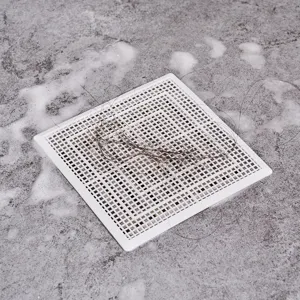 Square white plastic floor drain hair catcher filter net for bathroom shower drainage.