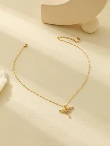 Gros plan détaillé d'un collier plaqué or avec un pendentif libellule en strass.