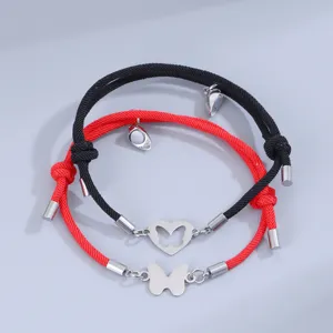 Primer plano detallado de pulseras de pareja a juego con corazón y mariposa magnéticos.