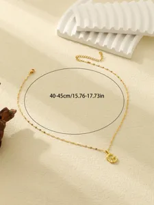 Elegante goudkleurige ketting met gestructureerde letterhanger en verstelbare ketting.