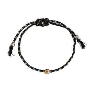 Exquisite detail of black and white braided cotton rope bracelet with a central gold bead.