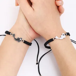 Conjunto de pulseras de pareja trenzadas a mano con dijes de peces en blanco y negro ajustables.