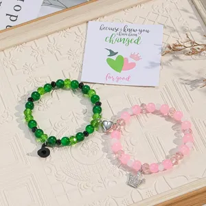 Detaillierte Nahaufnahme von passenden Pärchen-Magnetperlenarmbändern mit Zauber- und Kronen-Charms.