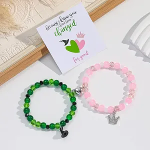 Magnetische Perlen-Paararmbänder Set mit Hexenhut und Kronen-Anhängern, grün und rosa.