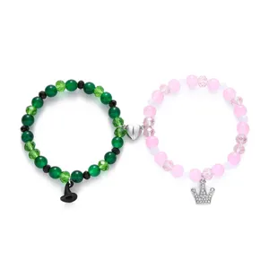 Magnetische Partnerperlenarmbänder in Grün und Pink mit Hexenhut und Kronenanhängern.