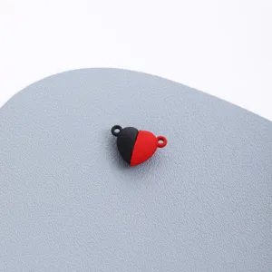 Close-up detail of heart magnetic clasp DIY jewelry accessory connector, black red.