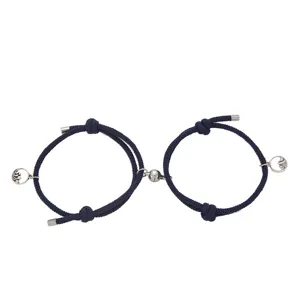 Coppia di bracciali intrecciati magnetici da uomo e donna con corda blu e ciondoli.