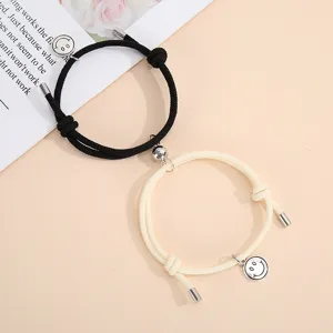 Magnetic couple braided bracelets set with cute smiley face pendants for matching wear details.