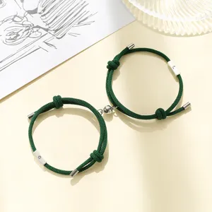 Green magnetic couple bracelets set with sun and moon charm matching braided rope jewelry detail