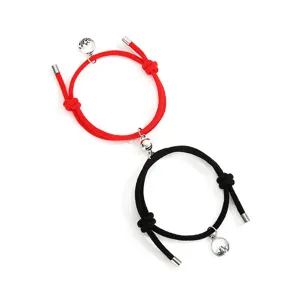 Grazioso set di bracciali di coppia magnetici con corde intrecciate rosse, ciondoli in lega.