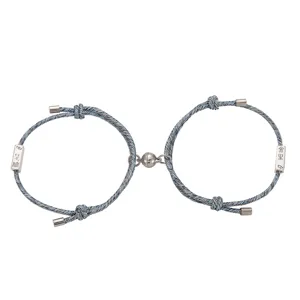 Set di bracciali in corda intrecciata magnetica di coppia con etichette metalliche blu.