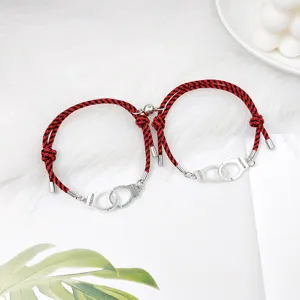 Détail de bracelet tressé magnétique pour couple, corde rouge et noire avec menottes en alliage.