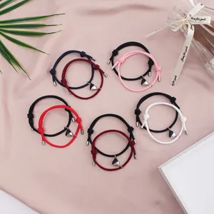 Detail view of matching couple magnetic heart braided rope bracelets in various colors.