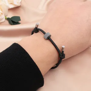 Black tactical survival rope bracelet detail with grey tungsten carbide gear bead and metal tips.