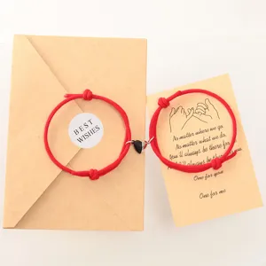 Couple magnetic red string bracelet set with matching heart charms and kraft paper cards.