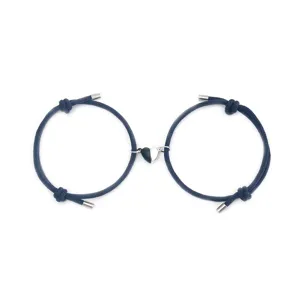 Close-up detail of magnetic couple bracelet with dark blue braided cord and heart charm.
