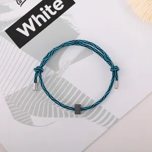 Detailed view of blue black woven survival bracelet with metal tips and tungsten bead.