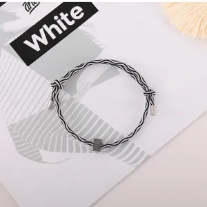 Black and white woven rope bracelet with metal charm and adjustable daily design.
