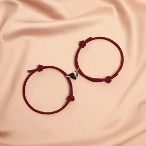Matching couple braided rope bracelets with magnetic black and white heart charms for besties.