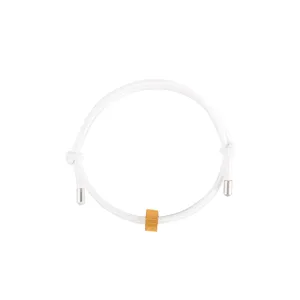Close-up detail shot of minimalist white woven cord bracelet with gold metal cylinder bead.