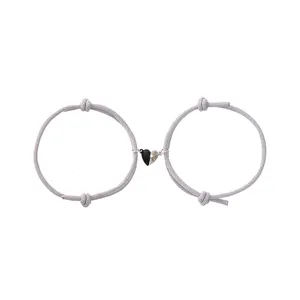 Detailed view of fashionable black and white heart magnetic couple bracelets in Milan rope.