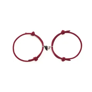 Matching red braided rope couple bracelets with a black and white magnetic heart pendant detail.