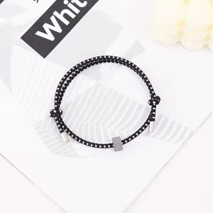 Black white woven survival bracelet with metal ends and tungsten bead for outdoor wear