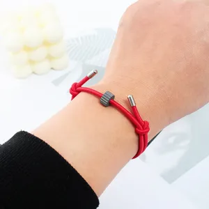 Red rope survival bracelet with tungsten carbide bead for outdoor emergency use and daily wear.