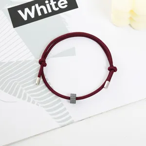 Burgundy rope bracelet with metal tips and tungsten bead, minimalist survival accessory detail view.