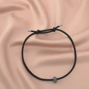 Minimalist black survival rope bracelet with metal tips and tungsten carbide bead detail close-up.