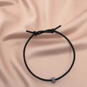 Minimalist black elastic survival bracelet with tungsten carbide glass breaker bead for daily wear.