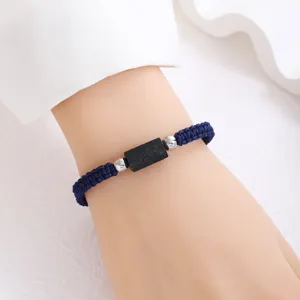 Dettaglio bracciale intrecciato in tormalina nera minimalista, corda regolabile fatta a mano.