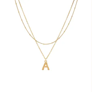 Squisita collana con catena doppia dorata con dettaglio di ciondolo lettera delicato.