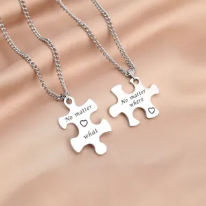 Stainless steel couple puzzle necklace detail showing engraved heart love pendants clearly.