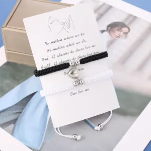 Vista dettagliata dei bracciali intrecciati di coppia abbinati con cuore magnetico.