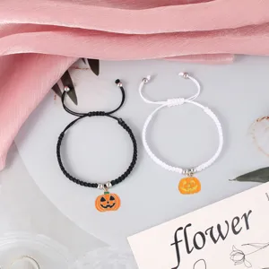 Detailed shot of Halloween pumpkin woven couple bracelets in black and white rope styles.