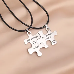 Close-up detail of stainless steel puzzle couple necklace with engraved romantic text.