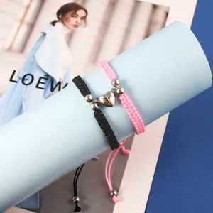 Set di bracciali di coppia magnetici con cuore intrecciati a mano, nero e rosa abbinati.