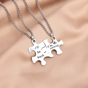 Detailed close-up of interlocking puzzle couple necklaces made of stainless steel with engravings.